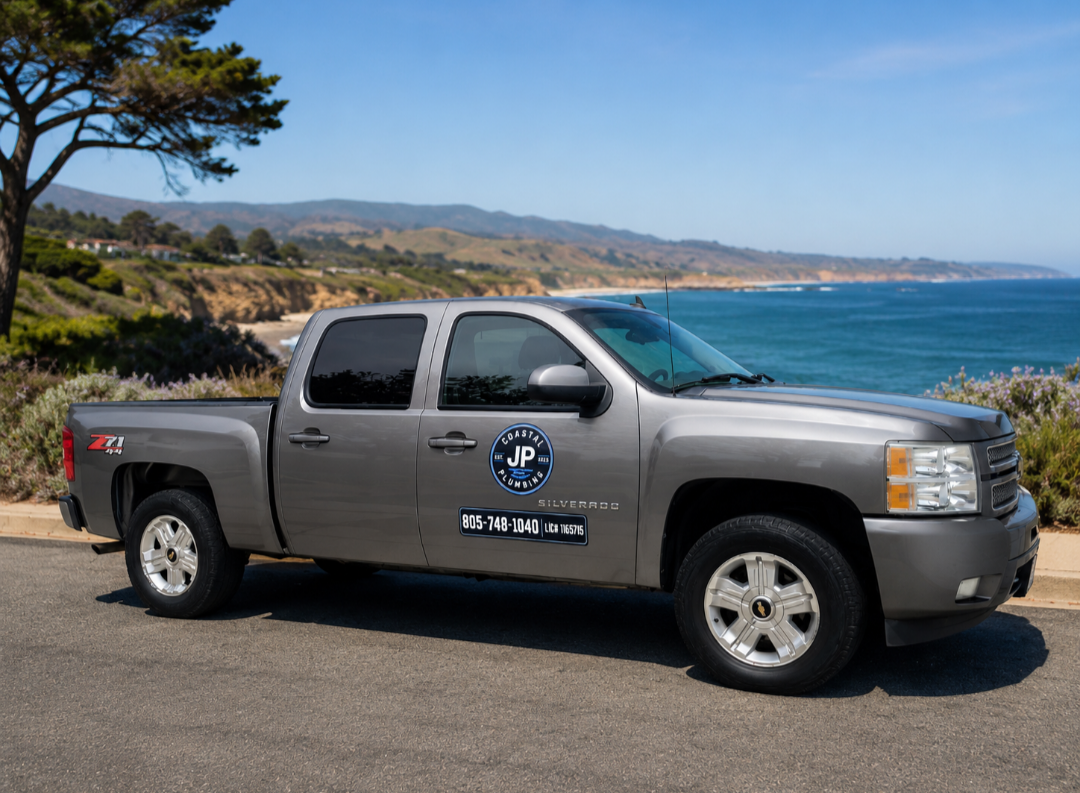 JP Coastal Plumbing service truck parked on a coastal bluff overlooking the ocean.
